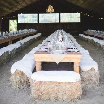 Pea straw bale chairs arranged for a long table wedding reception